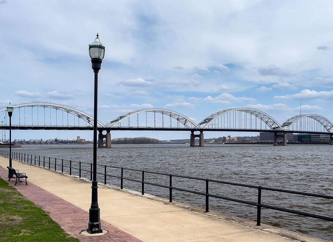 Rock Island, IL - View of a Bridge Across the Water Leading to Rock Island Illinois on a Cloudy Day